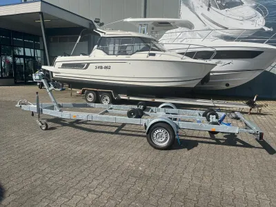 boottrailer op parkeerplaats met boot op de achtergrond