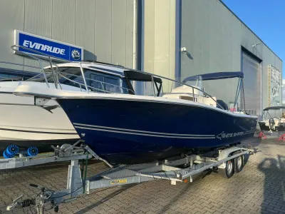 blauwe consoleboot op trailer bij loods