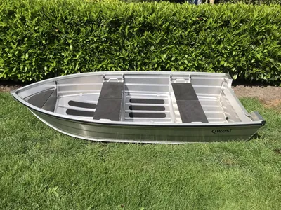 kleine aluminium boot op gras met heg
