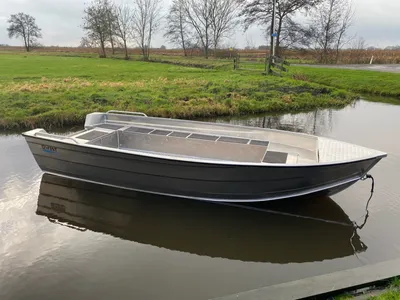 Aluminium boot op kanaal met grasland op achtergrond