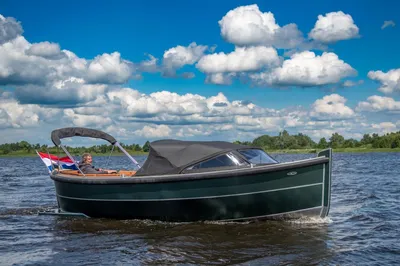 sloep op open water met bewolkte lucht