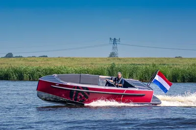rode tender op het water met Nederlandse vlag
