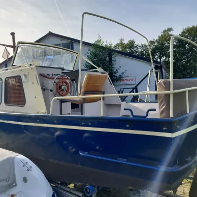 blauwe kajuitboot op trailer