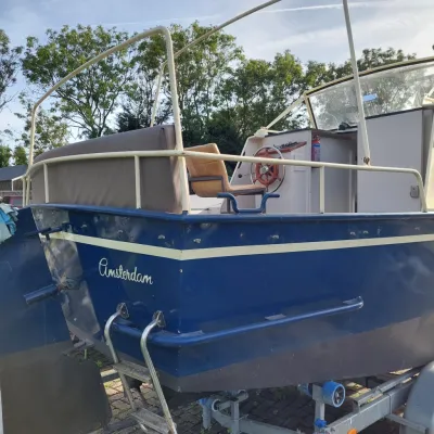 blauwe motorboot op trailer