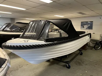 witte sloep met zwarte kap in showroom