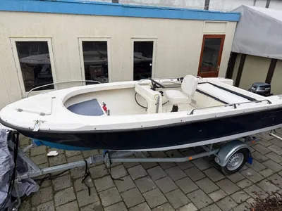 wit-blauwe open visboot op trailer