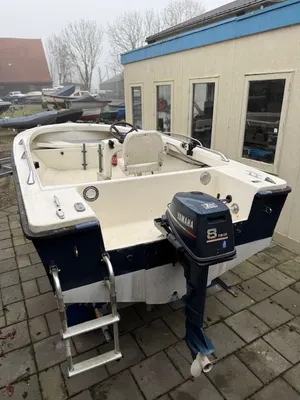 open vissersboot op oprit naast gebouw