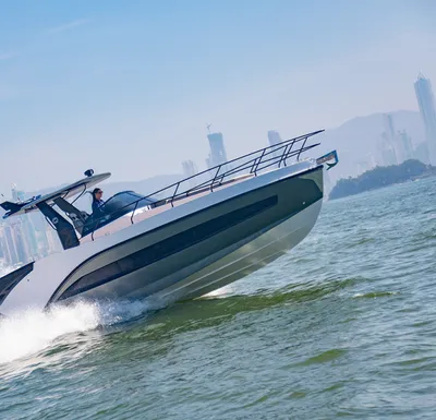 sportcruiser op open water met stad op achtergrond