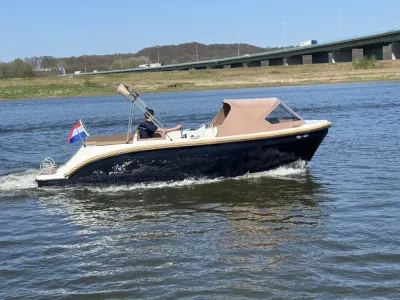 kleine boot op rivier met kap en Nederlandse vlag