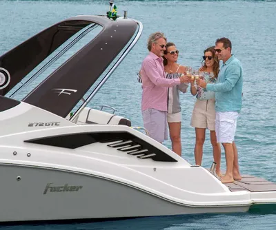 vier mensen proostend op zwemplateau van boot