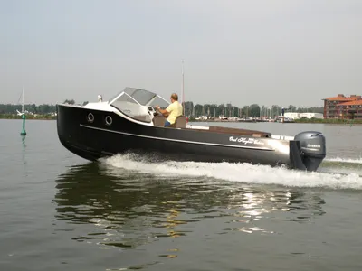zwarte cabineboot varend op rustig water