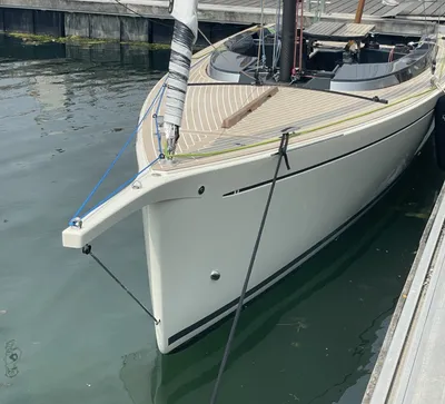 zeilboot bij steiger, boeg en dek zichtbaar