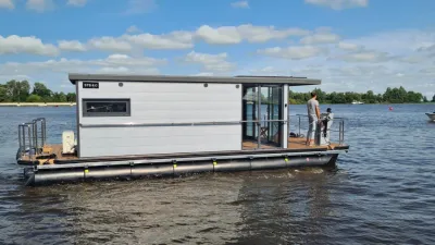 woonboot op het water met persoon op achterdek