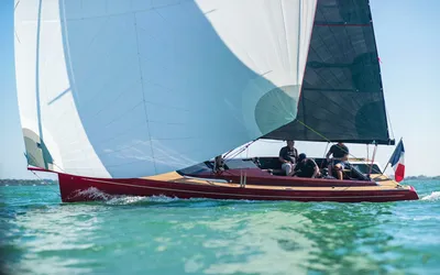 zeiljacht met witte grootzeil en bemanning
