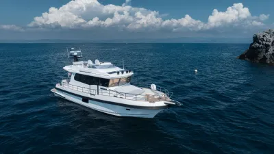 wit motorjacht op zee bij rotsachtige kust