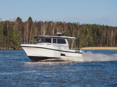 wit pilothuisjacht op water bij bosrand