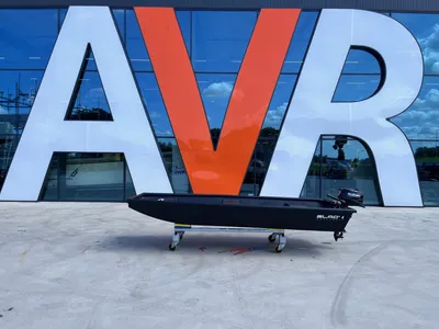 kleine zwarte werkboot op rolstelling voor gebouw