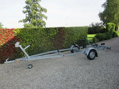 boottrailer op grind met haag op achtergrond