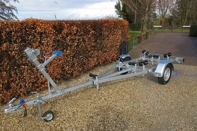 boottrailer op grindpad naast haag