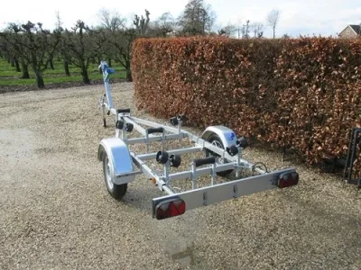 boottrailer op grindpad naast haag