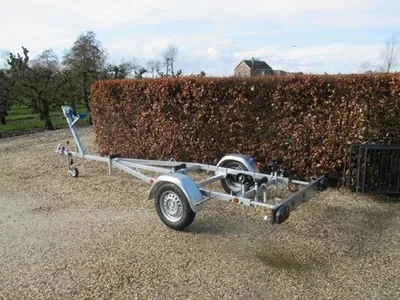 boottrailer op grindpad voor haag