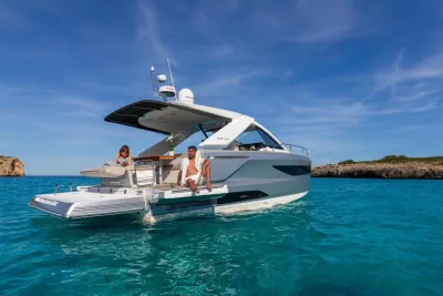 jacht op helder blauw water bij rotsachtige kust