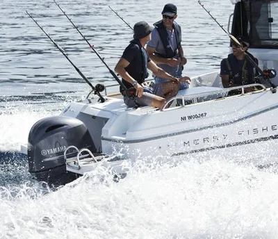 drie personen vissend op een motorboot