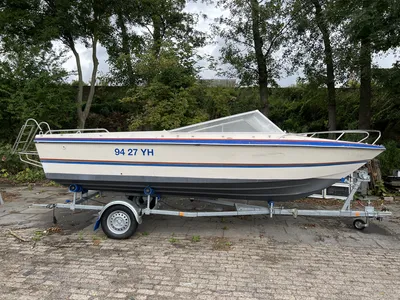 speedboot op trailer bij bomen