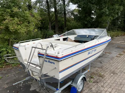 snelboot op trailer geparkeerd bij bomen