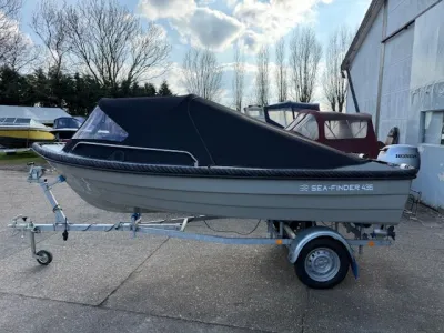 Kleine motorboot met cabrioletkap op trailer