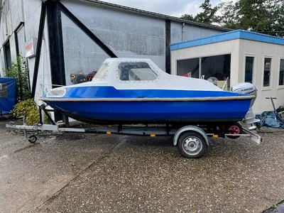 kleine blauwe boot op trailer voor gebouw