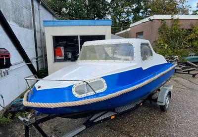 blauwe kleine boot op trailer in erf