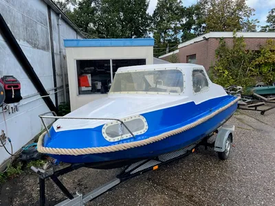 blauw-witte kajuitboot op trailer