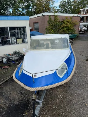 blauwe-witte kleine boot op trailer