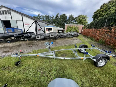 boottrailer op gras bij boten en gebouwen