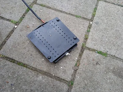 zwart elektrisch onderdeel op stoeptegels