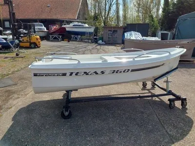 witte sloep op trailer in buitenopslag