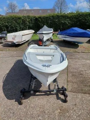 witte sloep op trailer bij andere boten