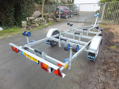 boottrailer op asfalt bij hek