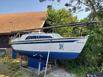 zeilboot op land naast schuur