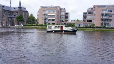 kajuitboot op water met gebouwen op achtergrond
