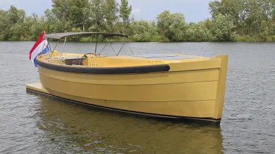 gele sloep op water met bomen op achtergrond