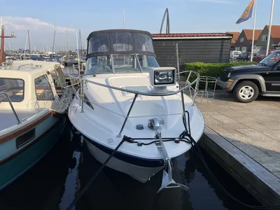 wit motorjacht aan steiger in jachthaven