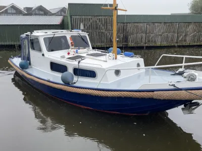 witte en blauwe motorvlet in haven