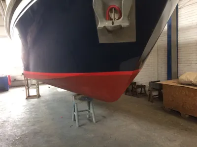 boeg van boot in loods op bokken