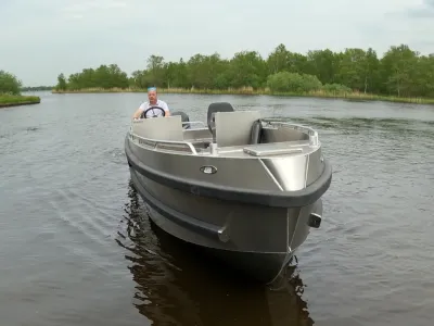 Aluminium motorboot op rivier met persoon aan boord