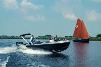 aluminium tender varend op een meer met opvarenden