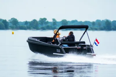 zwarte tenderboot met twee personen op het water