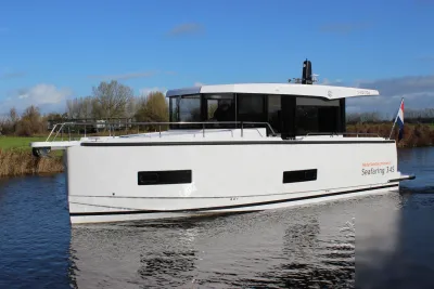 motorjacht op water met grasoevers en blauwe lucht