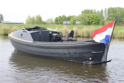 grijze open boot op water met vlag